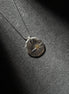 North Star sterling silver pendant necklace with brass center on dark textured background