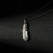 Handcrafted oxidized sterling silver feather pendant necklace with engraved feather details.
