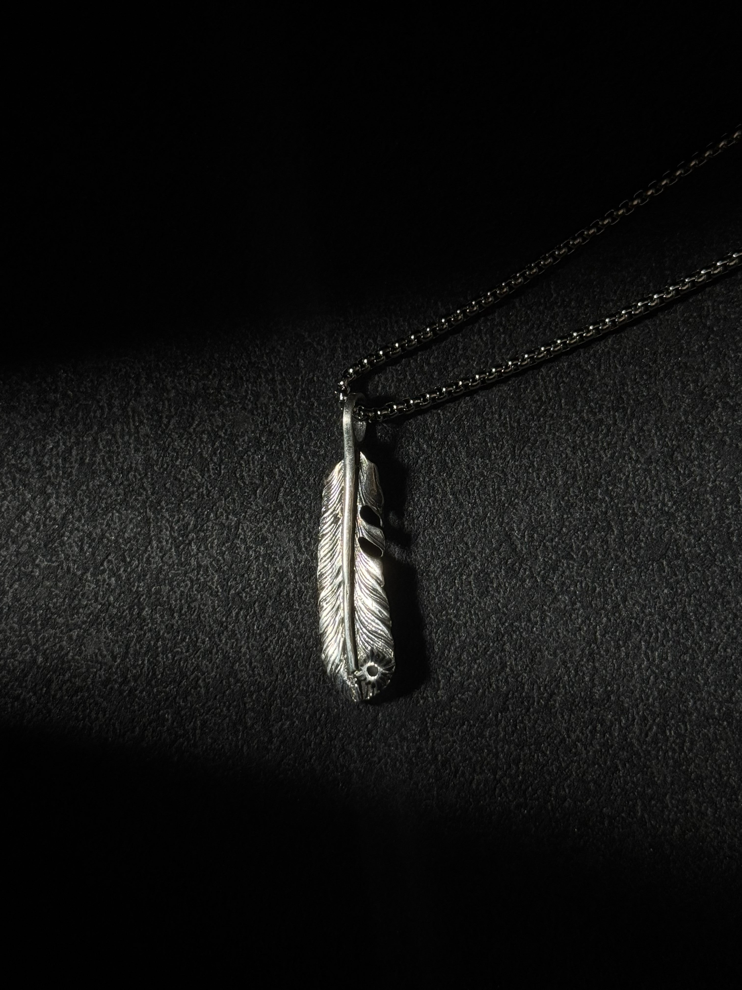 Handcrafted oxidized sterling silver feather pendant necklace with engraved feather details.